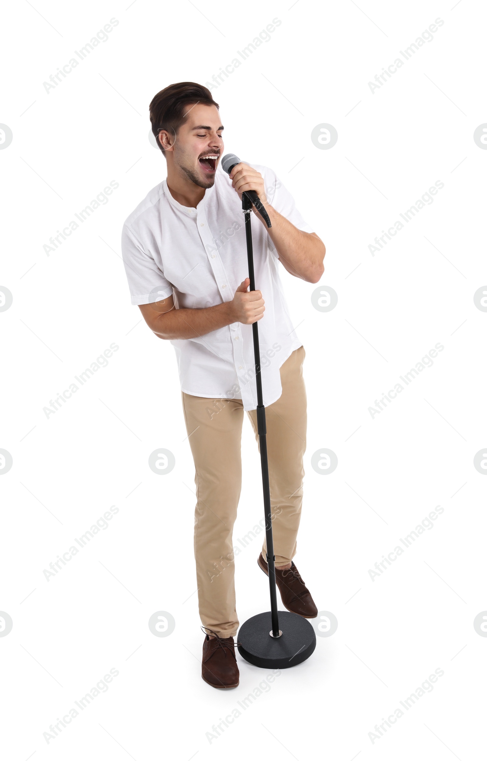 Photo of Young handsome man singing in microphone on white background