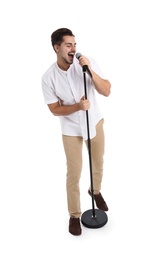 Young handsome man singing in microphone on white background