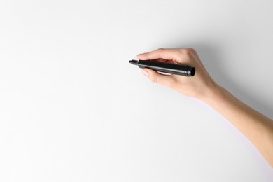 Photo of Woman holding black marker on white background, top view. Space for text