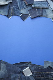 Photo of Frame made of cut jeans on blue background, top view. Space for text