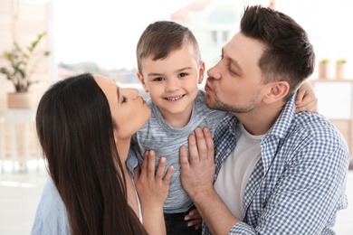 Happy parents kissing their son at home. Family time