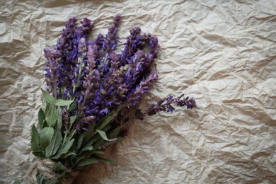 Photo of Bunch of beautiful salvia on parchment, top view. Space for text