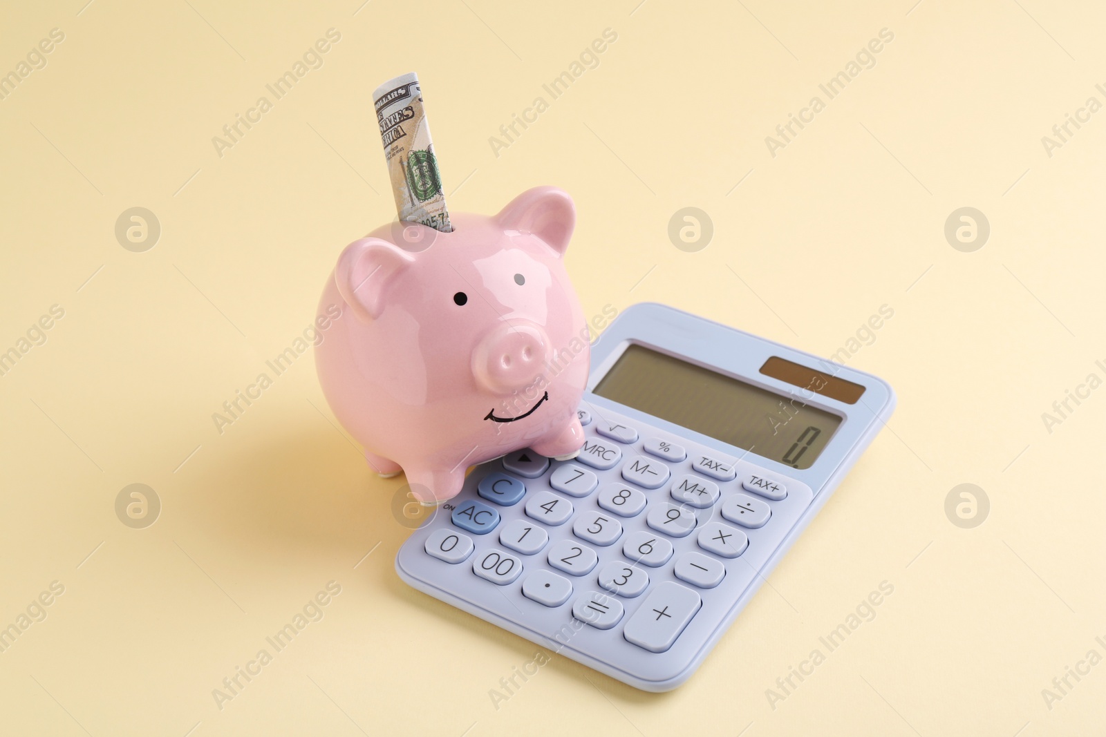 Photo of Financial savings. Piggy bank, dollar banknote and calculator on beige background