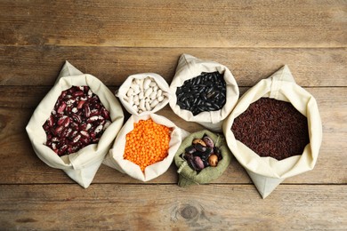 Photo of Different grains and seeds on wooden table, flat lay. Veggie diet