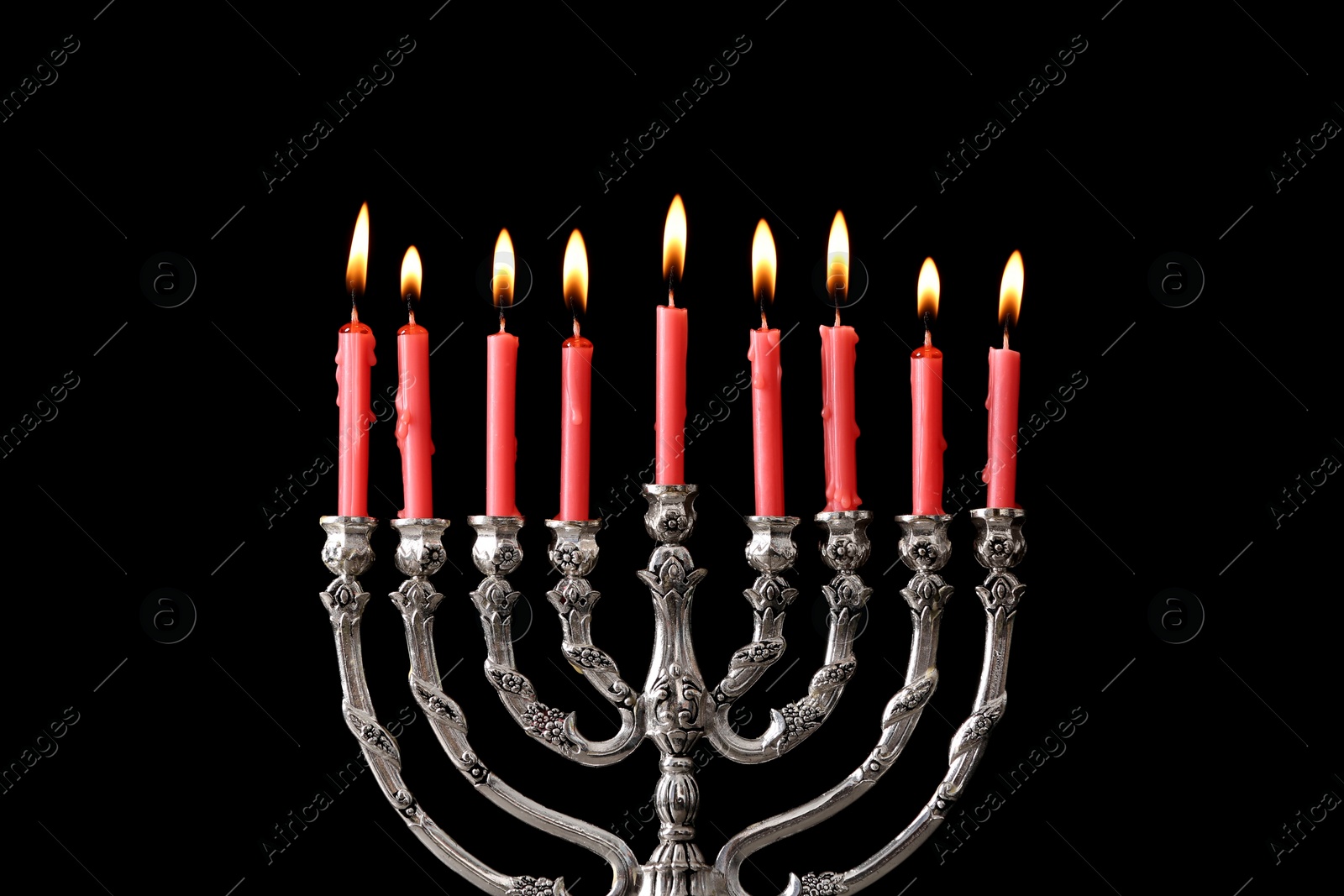 Photo of Silver menorah with burning candles against black background. Hanukkah celebration