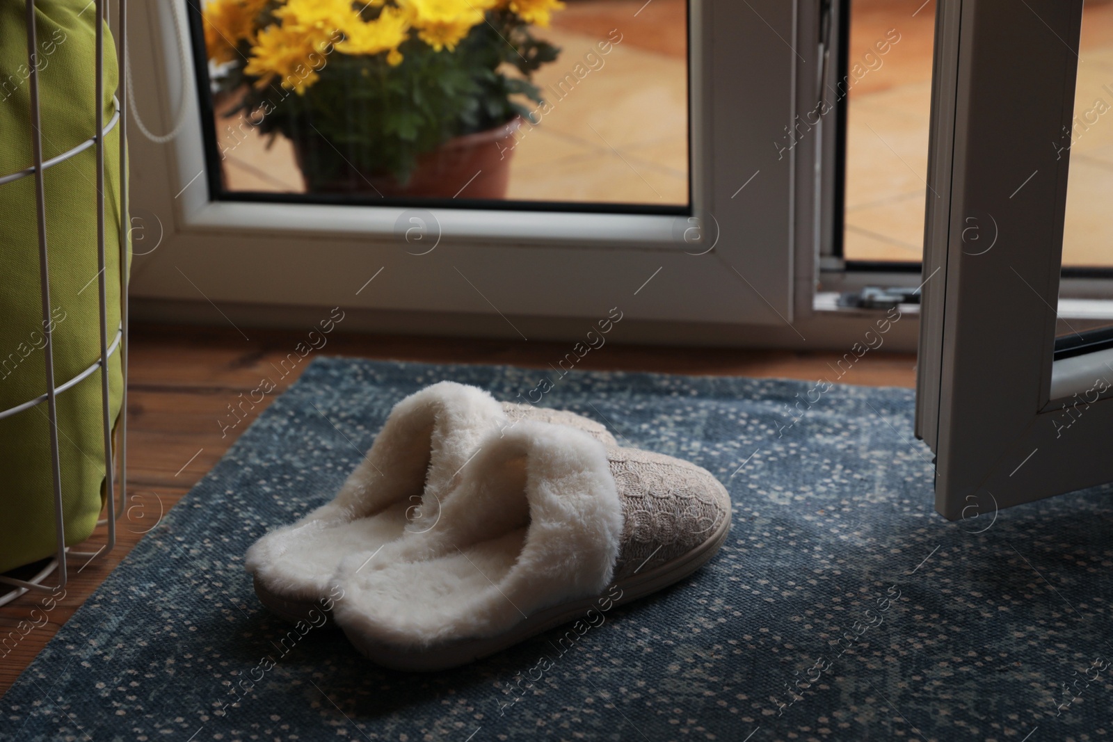 Photo of Stylish door mat and slippers on wooden floor indoors