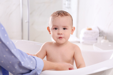 Photo of Mother with her little baby in bathroom