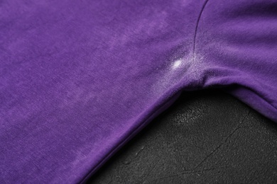 T-shirt with deodorant stain on black background, closeup