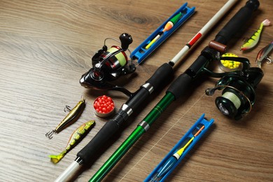 Photo of Spinning rods and fishing tackle on wooden background, closeup