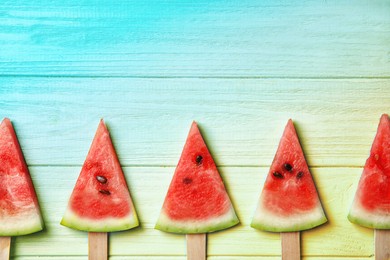 Watermelon popsicles on wooden background, flat lay with space for text. Summer party