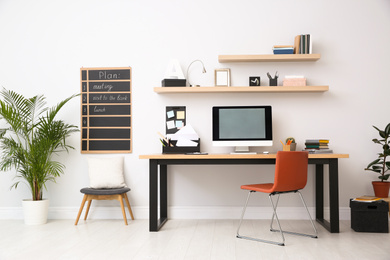 Photo of Modern computer on table in office interior. Stylish workplace