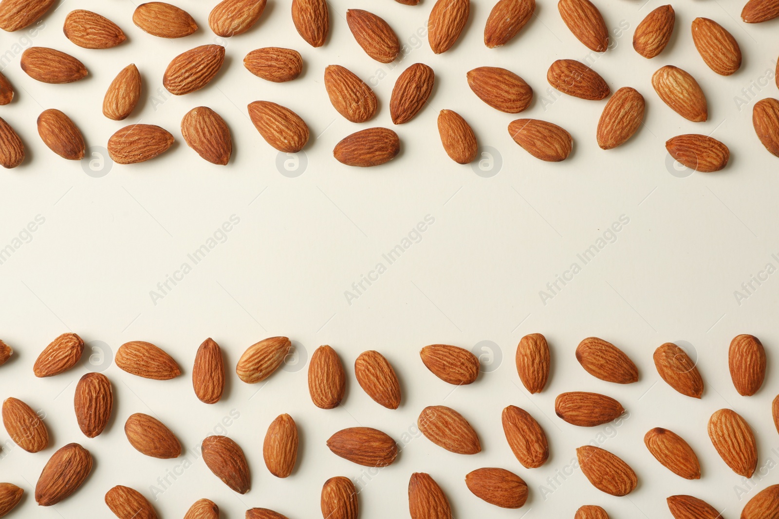 Photo of Composition with organic almond nuts and space for text on light background, top view