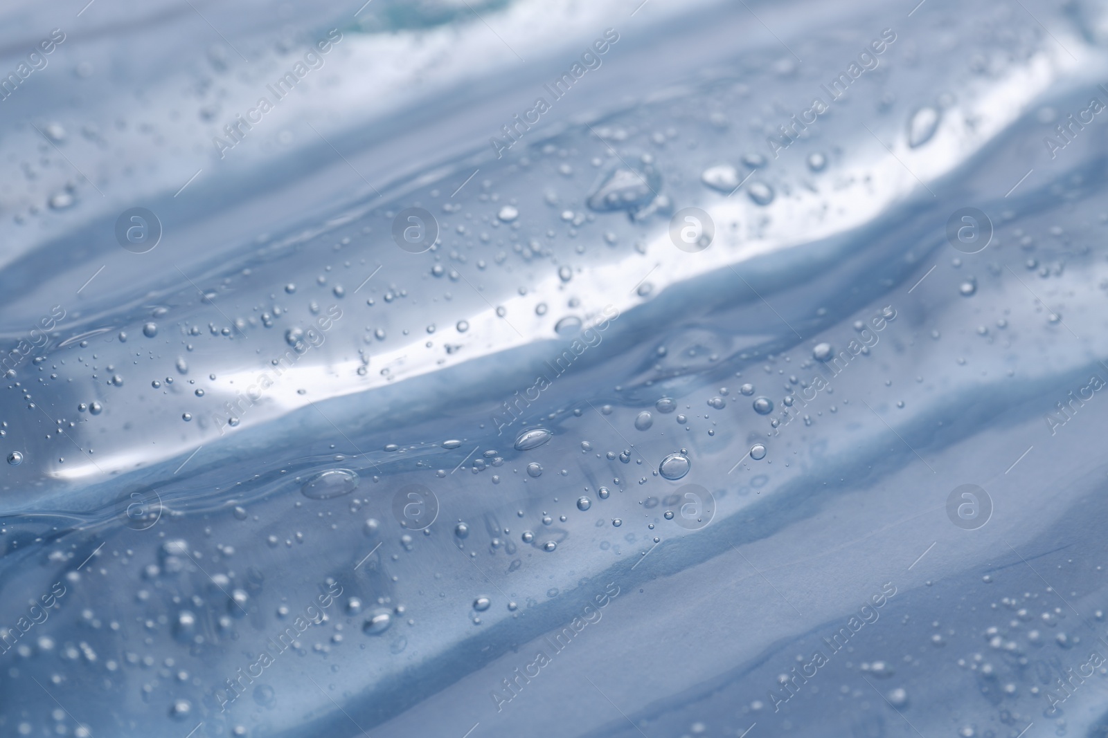 Photo of Texture of light blue shower gel as background, closeup