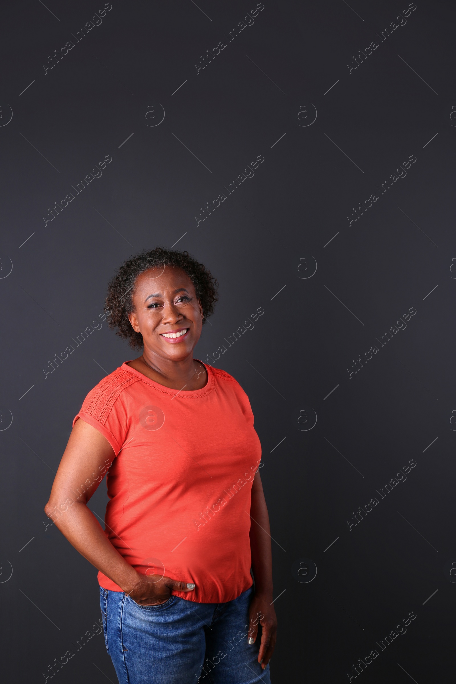 Photo of Portrait of happy African-American woman on black background