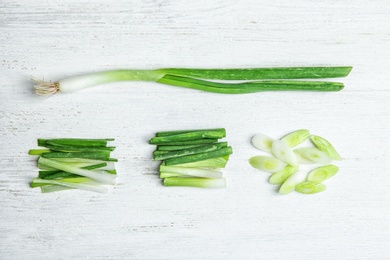 Photo of Fresh green onion on wooden table, top view