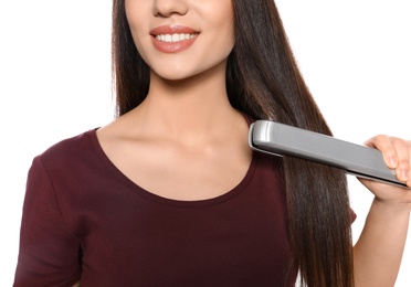 Photo of Happy woman using hair iron on white background, closeup