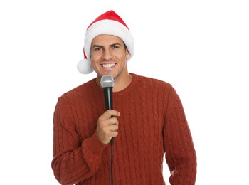 Happy man in Santa Claus hat with microphone on white background. Christmas music