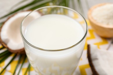 Photo of Glass of delicious coconut milk on table, closeup
