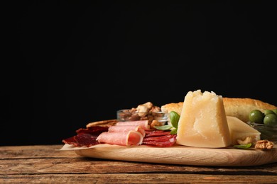 Photo of Snack platter with parmesan cheese served on wooden table. Space for text