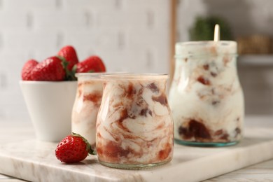 Tasty yoghurt with jam and strawberries on white wooden table, closeup