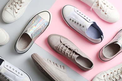 Photo of Flat lay composition with different sneakers on color background