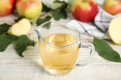 Photo of Natural apple vinegar and fresh fruits on white wooden table