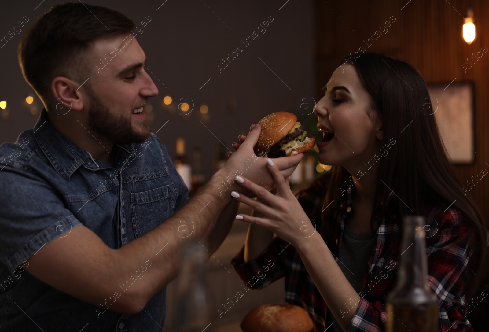 Photo of Young couple having lunch in burger restaurant