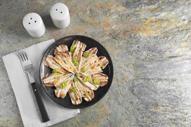 Tasty pickled anchovies with spices and fork on textured table, flat lay. Space for text