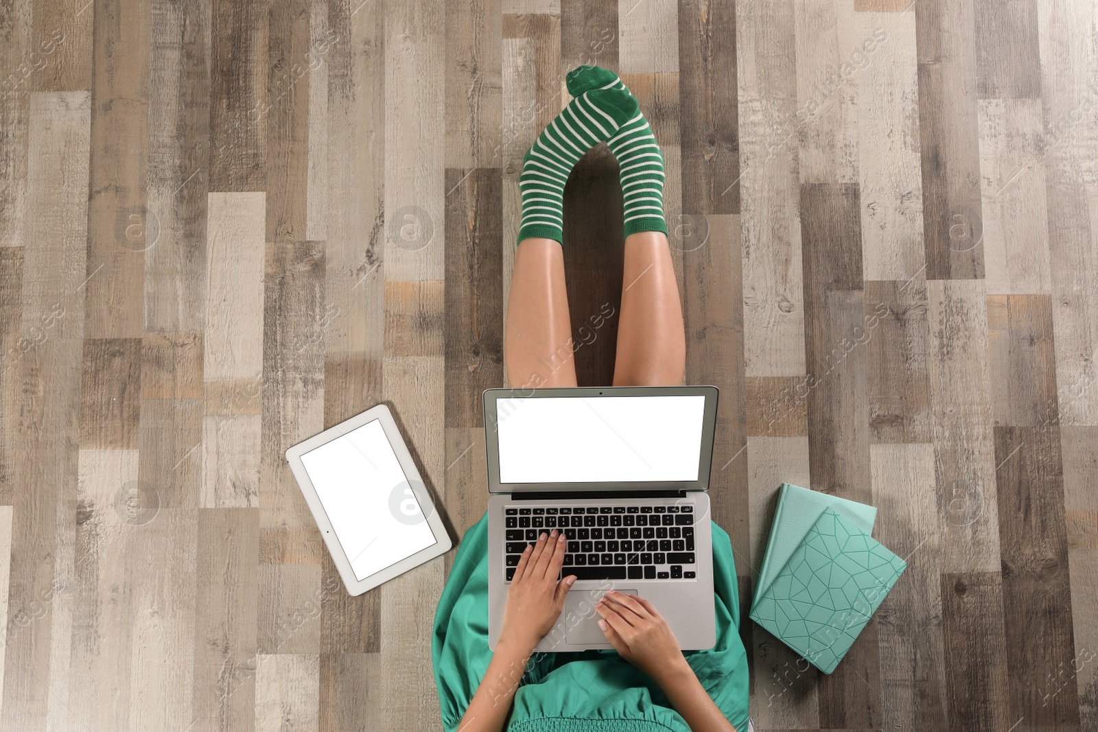 Photo of Top view of woman with laptop sitting on floor, closeup. Mockup for design