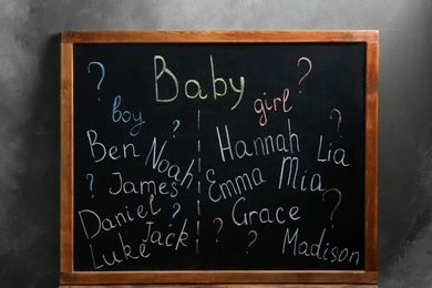 Blackboard with baby names near dark wall