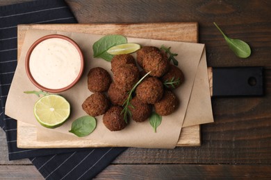 Photo of Delicious falafel balls served on wooden table, top view