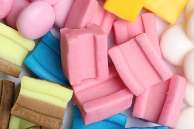 Different tasty colorful bubble gums as background, closeup