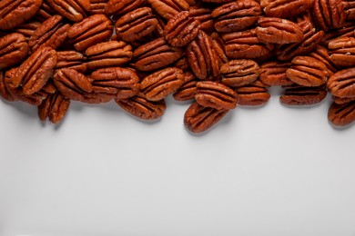 Photo of Delicious fresh pecan nuts on white background, flat lay. Space for text