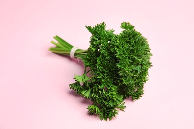 Photo of Bunch of fresh green parsley on pink background