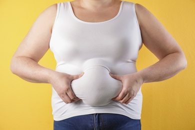 Overweight woman on color background, closeup. Obesity and weight loss