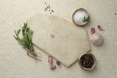 Photo of Cutting board, salt, pepper, rosemary and garlic on white textured table, flat lay. Space for text