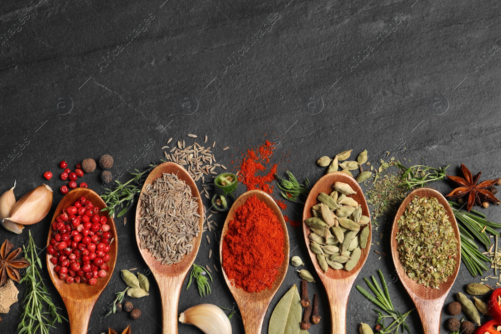 Photo of Flat lay composition with different natural spices and herbs on black table, space for text