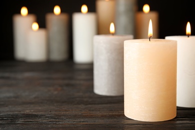 Photo of Many alight candles on table. Space for text