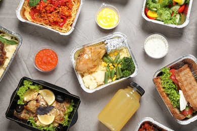Photo of Lunchboxes on grey table, flat lay. Healthy food delivery