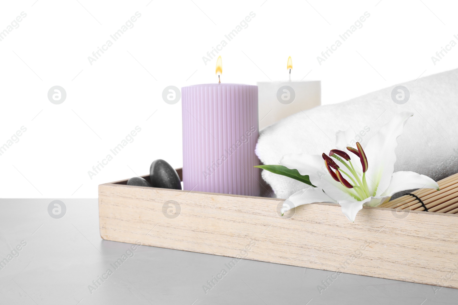 Photo of Tray with flower and spa supplies on marble table against white background