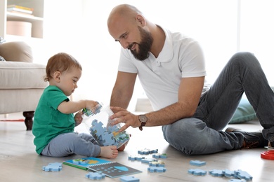 Dad and his little son playing together at home