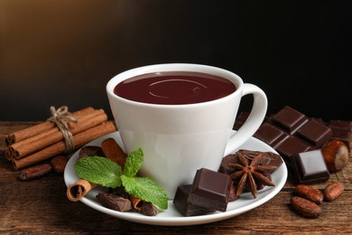 Photo of Yummy hot chocolate in cup on wooden table