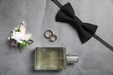 Photo of Wedding stuff. Flat lay composition with stylish boutonniere on gray background