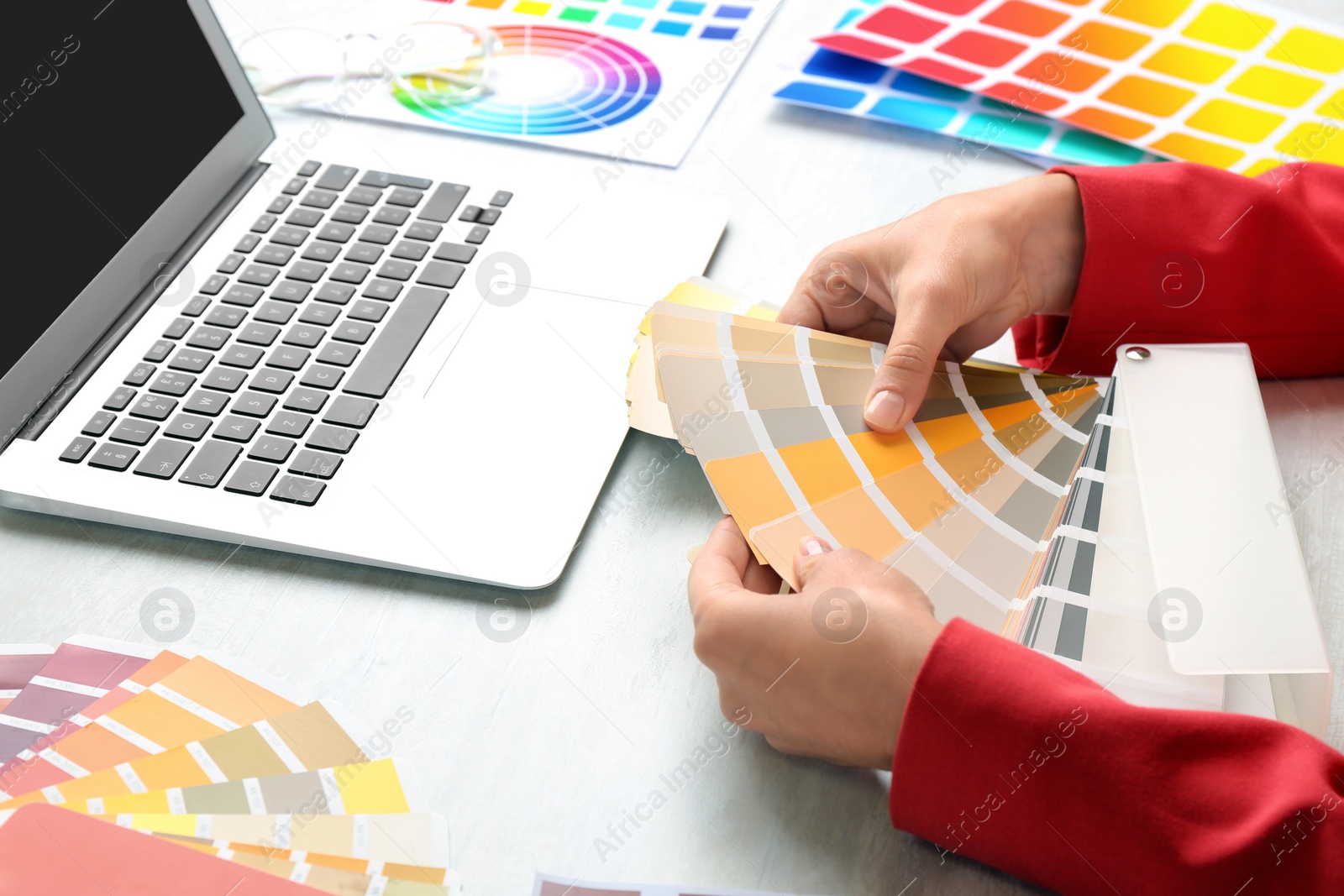 Photo of Woman with palette samples at white table, closeup