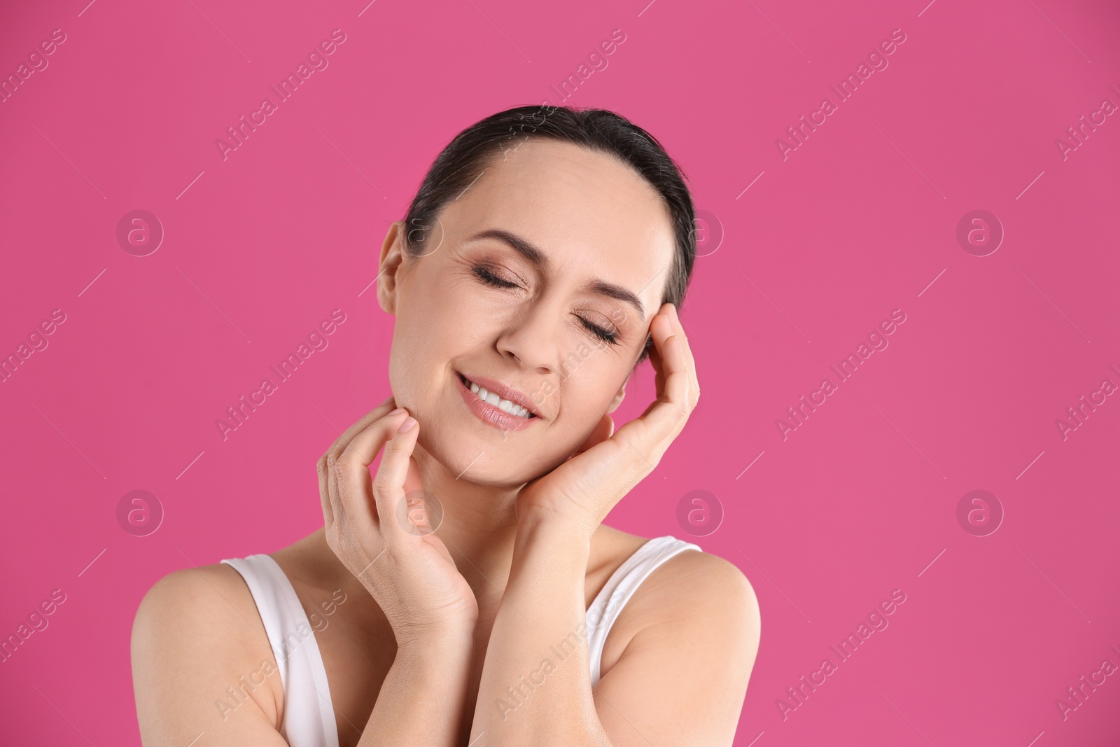 Photo of Portrait of beautiful mature woman on pink background