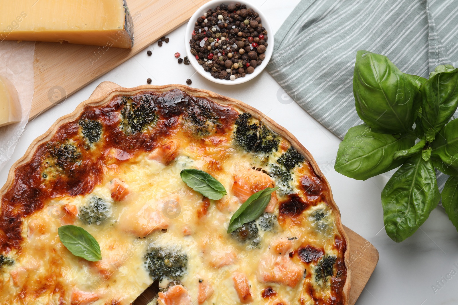 Photo of Delicious homemade quiche and ingredients on white table, flat lay