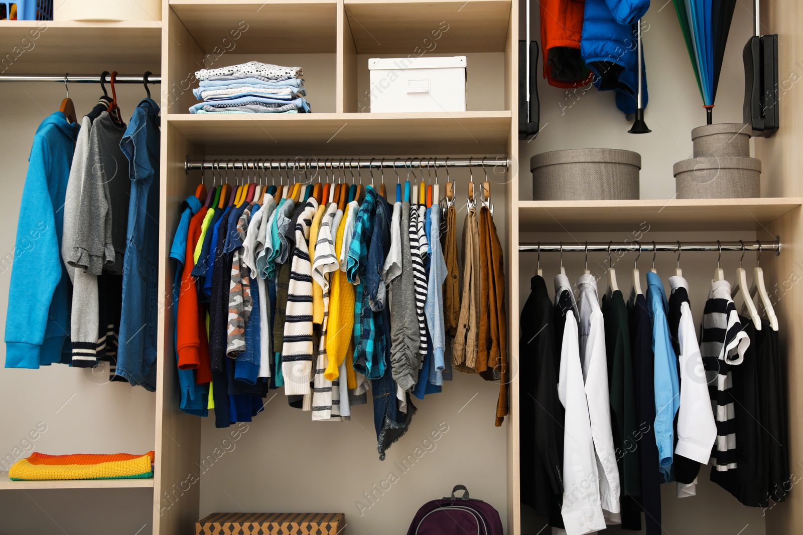 Photo of Large wardrobe with teenager clothes on hangers