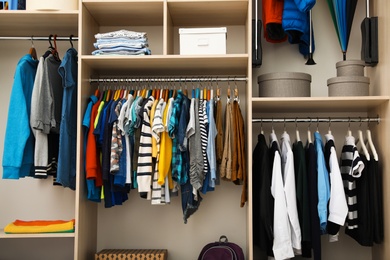 Photo of Large wardrobe with teenager clothes on hangers