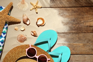 Flat lay composition with beach objects, sand and space for text on wooden background