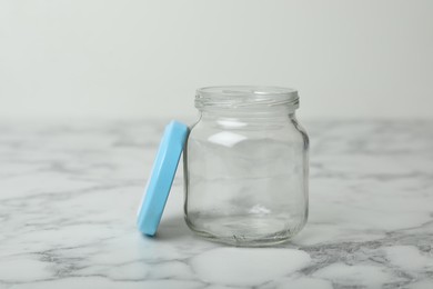 Empty glass jar on white marble table